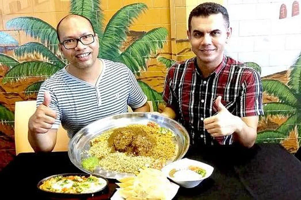 AYUH NIKMATI NASI MANDY: Encik Othmam Al-Jufrie (kiri) bersama sepupunya Encik Salim Al-Habshi menunjukkan makanan istimewa restoran Kakwan's Kitchen iaitu nasi mandy. - Foto KULINARY AFFAIRS