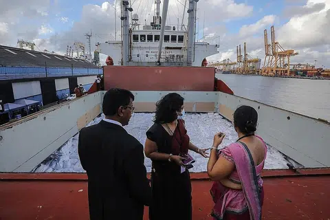 BANTUAN: Pegawai Sri Lanka memeriksa kapal yang membawa bantuan kemanusiaan yang didermakan pemerintah India di pelabuhan Colombo, Sri Lanka. - Foto EPA-EFE