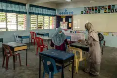 PASTIKAN JARAK SELAMAT DIPATUHI: Para guru menyusun meja dalam bilik darjah mengikut aturan jarak selamat di Sekolah Menengah Kebangsaan Seksyen 19 di Shah Alam, semalam. - Foto THE MALAY MAIL