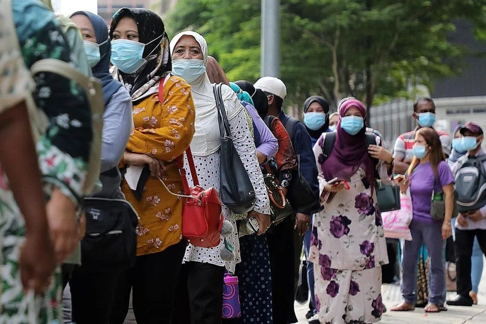 SESUAIKAN DIRI DENGAN NORMA BARU: Pengguna perkhidmatan awam seperti penumpang bas memakai pelitup semasa beratur untuk menaiki bas di tengah-tengah pandemik Covid-19 di Kuala Lumpur. - Foto REUTERS 