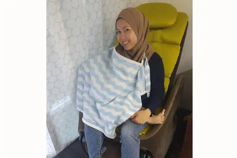 SELESA MENYUSUKAN BAYI DI TEMPAT AWAM: Cik Norliza Ibrahim menggunakan kain bagi menutup bayi dan dadanya semasa menyusukan anaknya. - Foto ihsan NORLIZA IBRAHIM