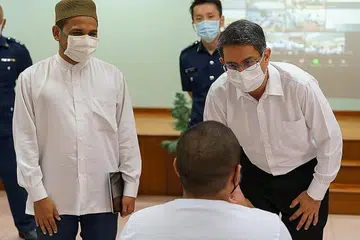 CERAMAH MOTIVASI: Mufti Dr Nazirudin Nasir (kiri) dan Dr Muhammad Faishal Ibrahim, meluangkan masa berbual dengan tahanan di sesi ceramah yang diadakan di Penjara Tanah Merah pada 30 Mac 2021. - Foto PERKHIDMATAN PENJARA SINGAPURA