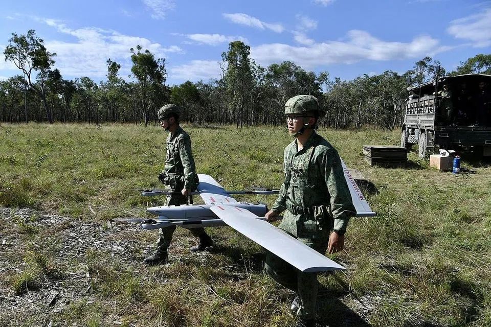 USAHA PERISIKAN: Dua anggota SAF kelihatan menyediakan UAV V-15 di satu kawasan latihan di Shoalwater Bay, Queensland, Australia kelmarin. - Foto BH oleh DESMOND FOO