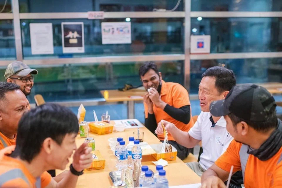 PENGHARGAAN BUAT PENGORBANAN PEKERJA: Encik Ong Ye Kung (dua dari kanan) bersembang sambil bersahur dengan pekerja Islam di SBS Transit Ltd yang menyenggara kereta api di Depoh Sengkang pada awal pagi Sabtu (17 April). - Foto-foto FACEBOOK ONG YE KUNG