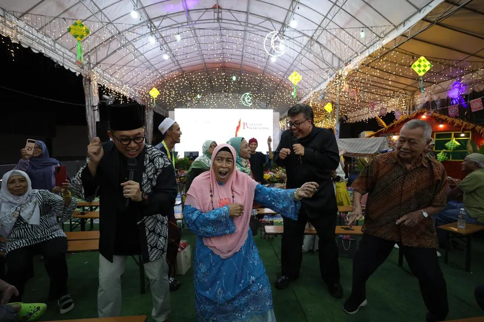 Artis tempatan, Rudy Djoe (kiri) dan Suhaimi Yusof (dua dari kanan) menari bersama pengunjung BazaRia semasa acara pelancaran bazar pada 27 Februari.