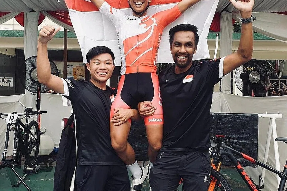 JUARA ASIA: Riyadh (tengah) didukung rakan sepasukan Jonathan Tan (kiri) dan pengurus Junaidi Hashim (kanan) selepas menjuarai acara Cross-Country Eliminator (XCE) di Kejohanan Lumba Basikal Urban Asia 2019 di Jakarta, Ahad lalu. - Foto Ihsan RIYADH HAKIM LUKMAN
