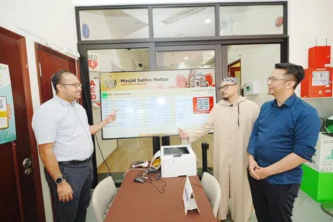 Pengarah bersama ISGN Ventures, Encik Fazli Mansor (kiri), dan Encik Fadzuli Wahab (kanan), bersama Eksekutif Operasi Masjid Sallim Mattar, Encik Muhammed Jamil Abdul Aziz (tengah), meneliti fungsi skrin paparan derma digital 75 inci yang kini beroperasi sepenuhnya di pekarangan masjid tersebut.