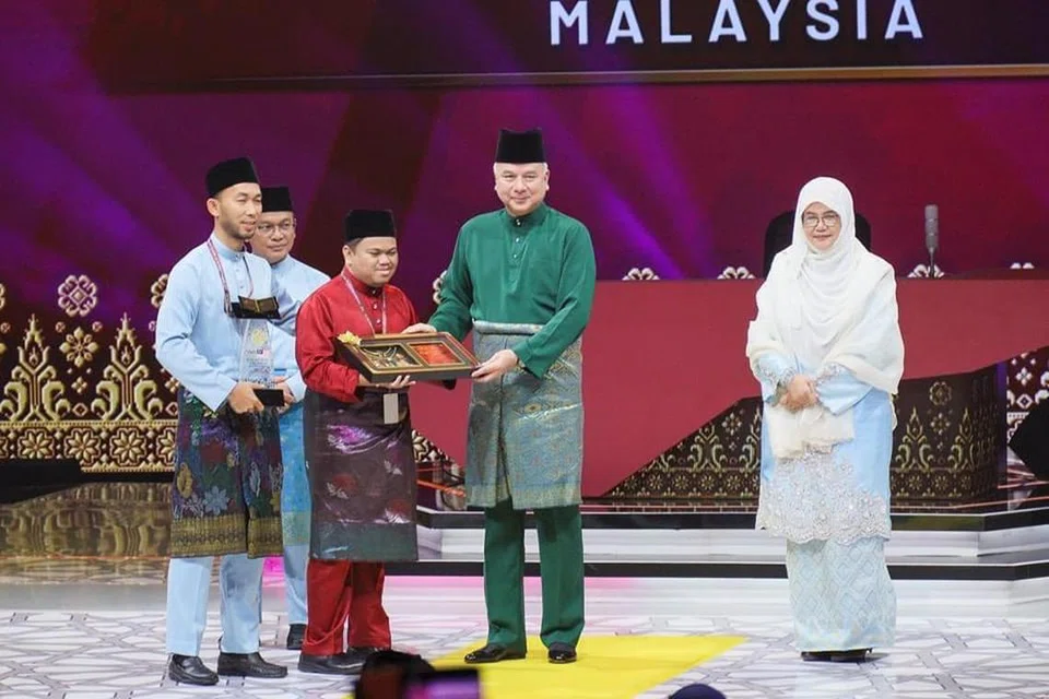 JUARA TILAWAH: Sultan Perak, Sultan Nazrin Muizzuddin Shah (baju Melayu hijau), menyampaikan hadiah kepada johan kategori lelaki, Encik Muhammad Qayyim Nizar Sarimi (baju Melayu merah). 