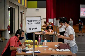 LEBIH DARIPADA CUKUP: Token penjejakan kontak TraceTogether kini boleh diambil di 38 kelab masyarakat, tetapi akan tersedia di semua 108 kelab masyarakat menjelang akhir bulan depan, dan ia "lebih daripada cukup". - Foto BH oleh LIM YAOHUI