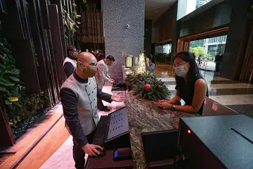 JALANI LATIHAN: Kakitangan concierge di hotel Parkroyal Collection Marina Bay, Encik Alfyro Ozaer Al Johary (kiri), menjalani latihan sejak Ogos lalu selepas hotel itu menerapkan penggunaan teknologi, seperti sistem concierge digital, untuk menyediakan pengalaman lebih baik dan lancar kepada tetamu. - Foto BH oleh KEVIN LIM