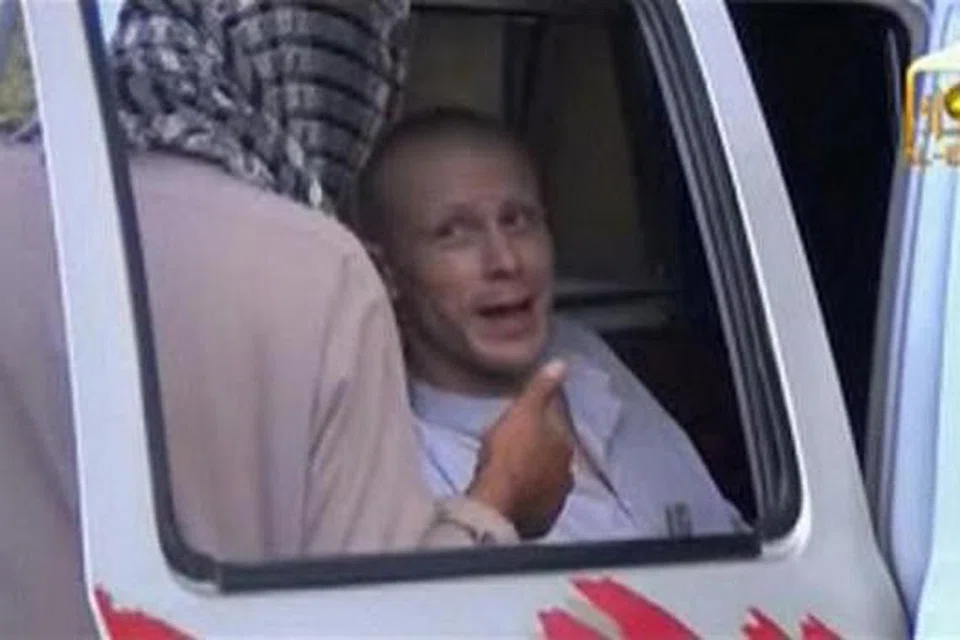 DIBEBASKAN: Imej dari video ini menunjukkan Sarjan Bergdahl (kanan) berbual bersama militan Taleban semasa menunggu di sebuah kenderaan sebelum dibebaskan di sempadan Afghanistan. - Foto REUTERS