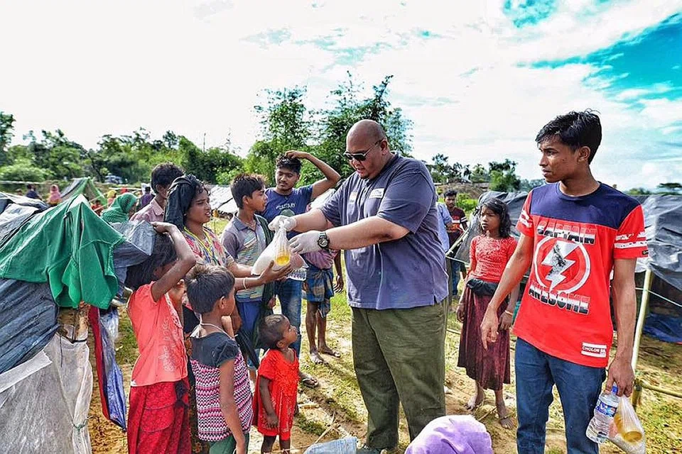 MEMBERI KELEGAAN: Pengarah Eksekutif (pemangku) Bapa, Ustaz Muhammad Fizar Zainal, menyampaikan bantuan kepada sekumpulan penerima di kem pelarian. - Foto BAPA RELIEF