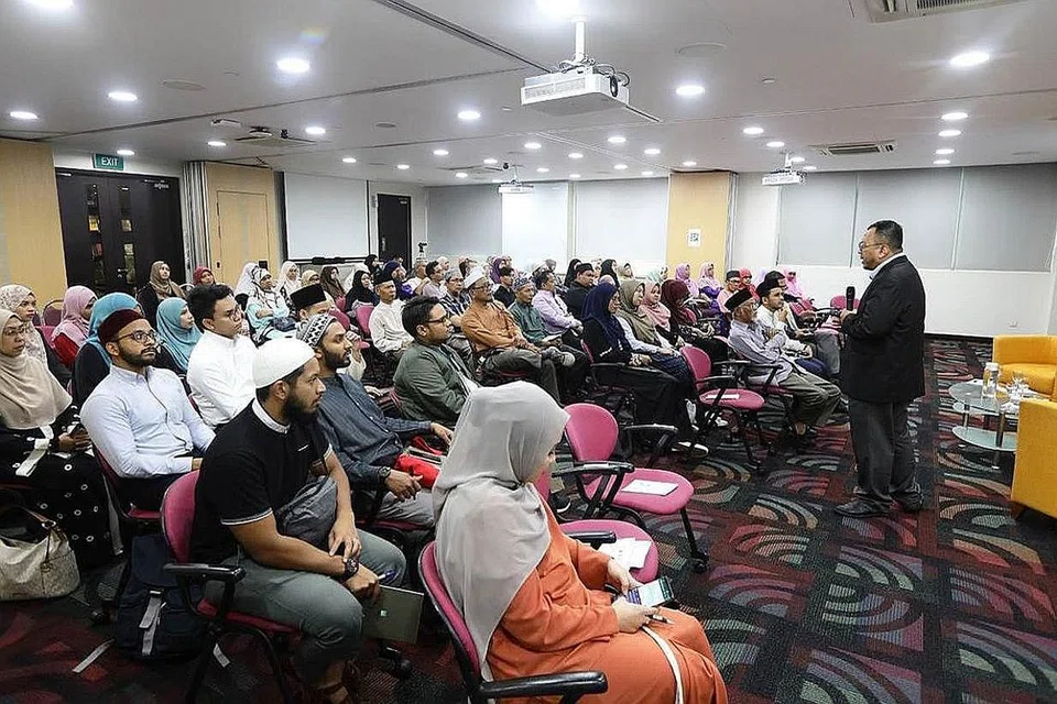 TAKLIMAT: Ketua PCICS, Dr Mohammad Hannan Hassan (berdiri), mengongsi maklumat tentang rangka kerja program PCICS bersama lulusan dan ibu bapa baru-baru ini. - Foto MUIS