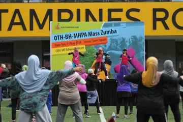 SIHAT BERZUMBA: Sekitar 150 orang tetap bersemangat menyertai acara Sihat Berzumba di Our Tampines Hub pagi tadi meskipun hujan.