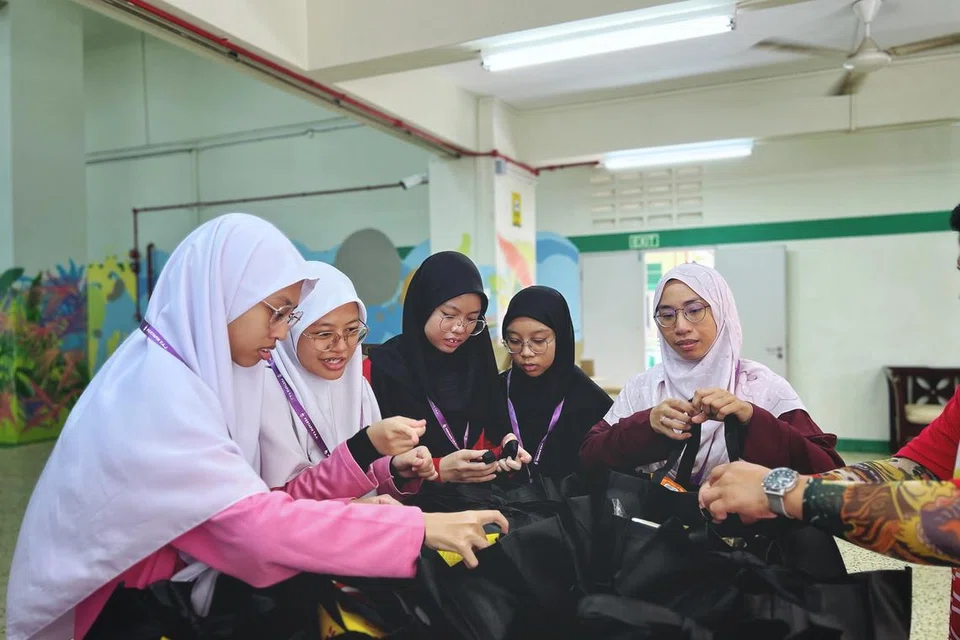 Ketua Pembangunan Pelajar, Madrasah Al-Ma’arif Al-Islamiah, Ustazah Nurhidia Suzieyanti Sulaimee (kanan) kelihatan memeriksa habuan bersama murid-muridnya pada acara ‘Food on Wheels’ anjuran Pertapis pada 2 Mac.
