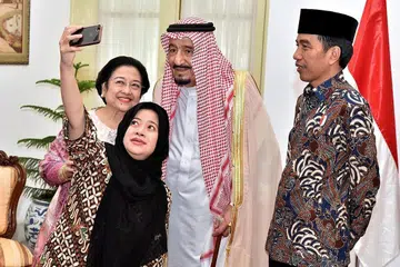 BER'SELFIE': Presiden Joko Widodo (kanan) memerhatikan mantan Presiden Megawati Sukarnoputri (belakang, kiri) dan anak perempuannya yang juga anggota Kabinet, Puan Maharani, berselfie dengan Raja Salman di Istana Presiden, kelmarin - Foto REUTERS