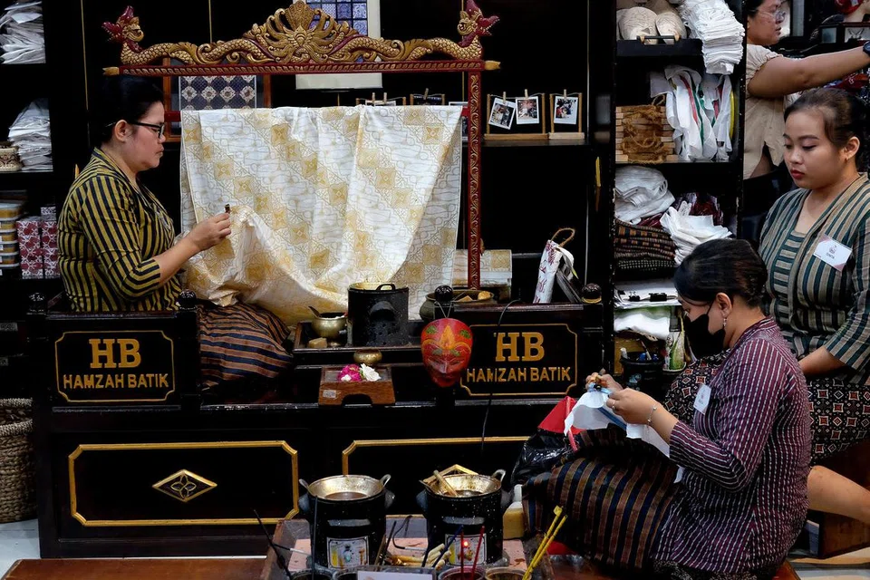 Pekerja di kedai Hamzah Batik menunjukkan cara membuat batik.