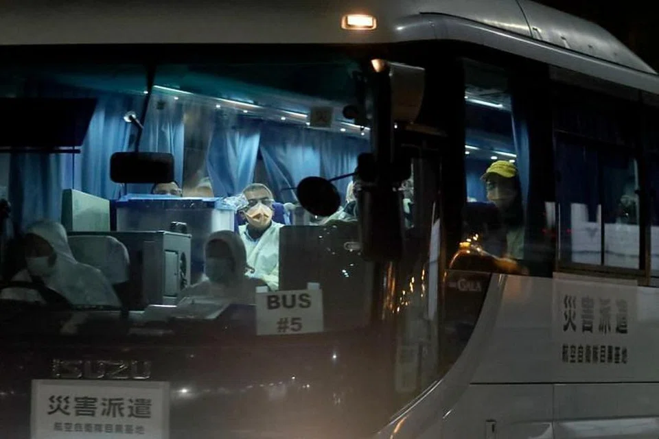 DIPINDAHKAN: Orang memakai pelitup muka duduk di dalam bas yang dipercayai membawa penumpang Australia dari kapal persiaran Diamond Princess, sedang ia meninggalkan Terminal Kapal Persiaran Tambangan Daikoku di Yokohama di selatan Tokyo, Jepun, pada Rabu (19 Feb).