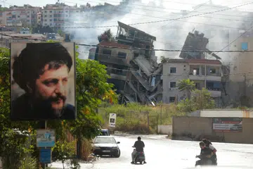 Penduduk melintas di hadapan bangunan yang musnah akibat pengeboman tentera Israel di selatan Beirut pada 20 Oktober.