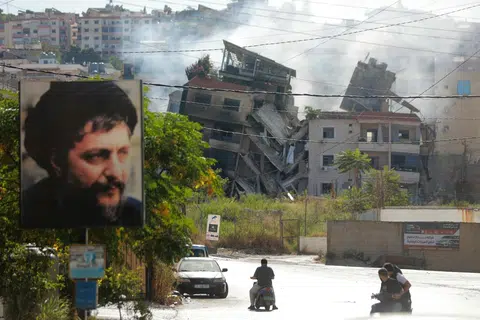 Penduduk melintas di hadapan bangunan yang musnah akibat pengeboman tentera Israel di selatan Beirut pada 20 Oktober.