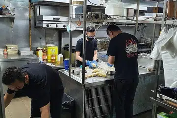 PERSIAPAN LENGKAP: Kakitangan restoran Steak Me di Jalan Kayu sedang sibuk membuat persiapan menjelang pembukaan esok, dengan kakitangan mengenakan pelitup dan sarung tangan semasa menyediakan makanan pelanggan. - Foto CEF AMRI