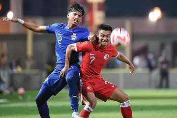 MENARIK TUMPUAN RAMAI: Pemain Singapura, Irfan Najeeb (kiri) bersaing dengan pemain Hong Kong Law Tsz Chun dalam satu perlawanan persahabatan di Stadium Mong Kok pada 2023.
