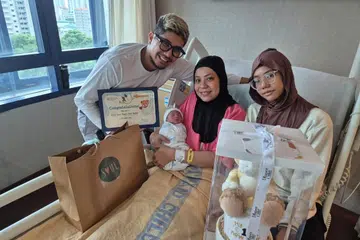 Encik Muhammad Hadi Harris (kiri) dan isteri, Cik Nur Faizah Hamid (tengah) menyambut kelahiran putera mereka, Muhammad Noah Rizq, pada 3.14 pagi di Hospital Wanita dan Kanak-Kanak KK (KKH) pada 1 Januari, dengan berat 3.07 kilogram. Bersama mereka ialah anak sulung mereka, Riquesya Nur Qistina Muhammad Hadi (kanan). 