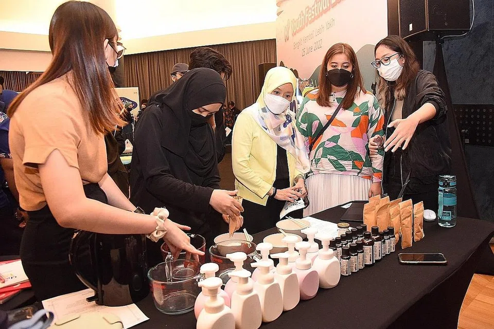 BUAT PEMBASUH TANGAN DIY: Cik Rahayu Mahzam (tiga dari kanan) dan Cik Nadia Samdin (dua dari kanan) menyaksikan demonstrasi proses membuat pembasuh tangan buatan sendiri sewaktu pelancaran Pesta Belia M³ 2022 di *SCAPE, The Tree Top semalam. - Foto BM oleh DESMOND WEE