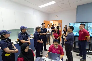 Menteri Pendidikan, Encik Desmond Lee (dua dari kanan), memerhatikan latihan kesiapsiagaan kecemasan Sekolah Menengah Bukit Batok.