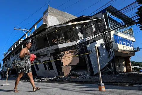 Seorang wanita berjalan melepasi sebuah bangunan yang runtuh sehari selepas gempa bumi berukuran 7.8 magnitud melanda kawasan Calumpang di General Santos, selatan Filipina, pada 9 Jun 2026.