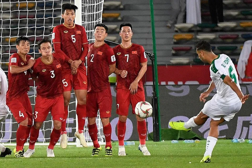 GOL KEMENANGAN: Ali Adnan (kanan) menyumbat masuk bola daripada tendangan bebas di minit terakhir bagi memastikan kemenangan 3-2 kepada Iraq ketika menentang Vietnam dalam perlawanan Kumpulan D kelmarin. - Foto AFP