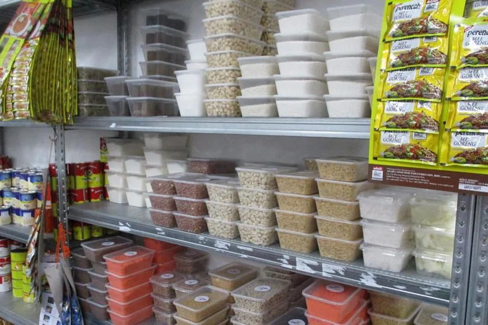 Syarikat Qiksmart membungkus semula makanan ke dalam bekas yang lebih kecil di sebuah tempat yang tidak berlesen di kawasan perindustrian di Ubi Crescent. - Foto SFA