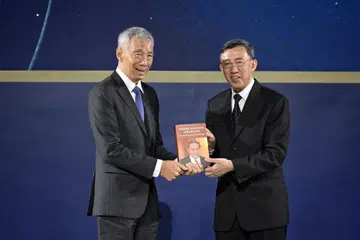 Hakim Andrew Phang (kanan) menyampaikan buku Pioneer, Polymath and Mentor – The life and legacy of Yong Pung How, kepada Perdana Menteri, Encik  Lee Hsien Loong, semasa pelancaran buku itu di Universiti Pengurusan Singapura (SMU) pada 11 April 2024.