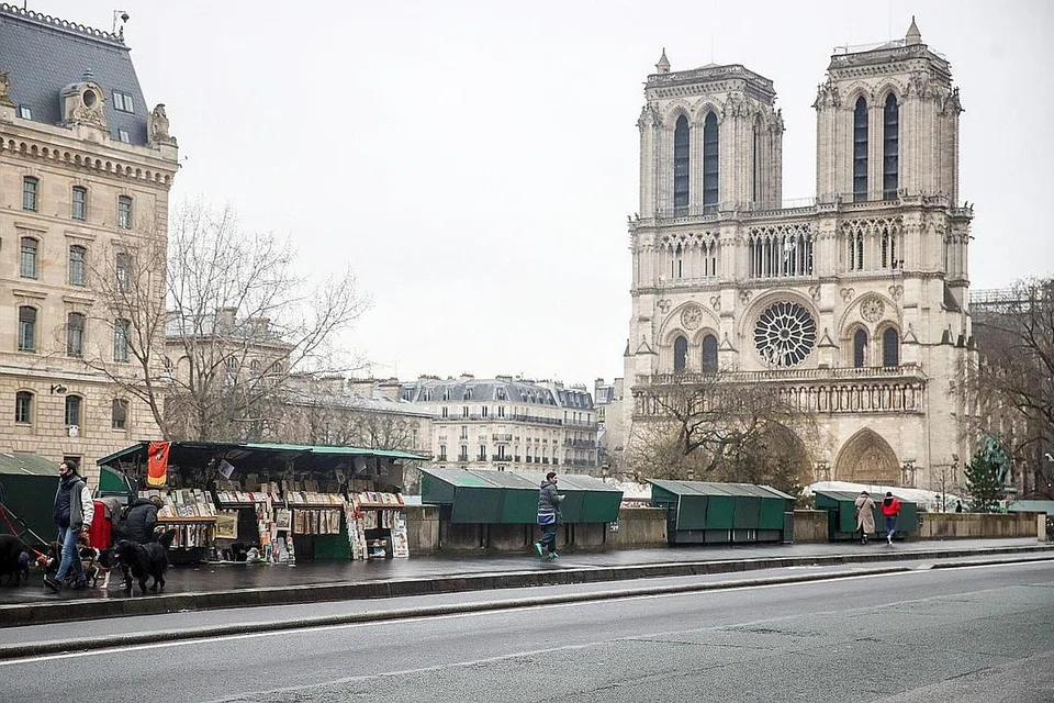 SEMAKIN MENINGKAT: Warga dilihat berjalan di tepi kios penjual buku yang kebanyakannya ditutup dekat Gereja Notre-Dame di Paris. Kadar jangkitan Covid-19 yang tinggi di Perancis telah mencetuskan keprihatinan sekatan pergerakan negara ketiga akan perlu dilaksanakan di negara itu. - Foto EPA-EFE