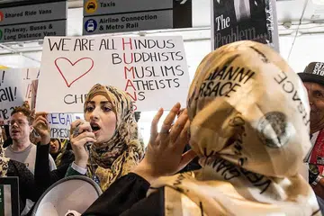 BANTAHAN DI LAPANGAN TERBANG:Cik Shemms Najjar (tengah) dari Torrence, California, memimpin bantahan menentang arahan eksekutif yang melarang penduduk daripada tujuh negara majoriti Islam di Lapangan Terbang Antarabangsa di Los Angeles, California. - Foto AFP