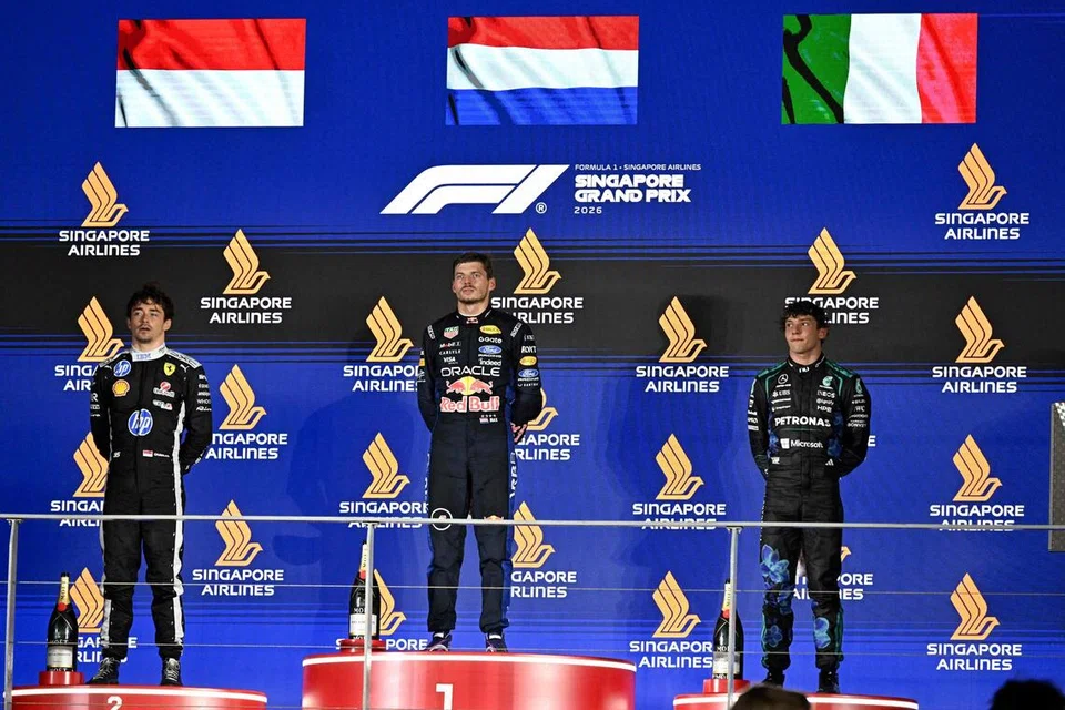 CATAT KEJAYAAN: Juara perlumbaan, Max Verstappen (tengah) dari Red Bull, bergambar bersama pemandu pasukan Ferrari dan pemenang tempat kedua, Charles Leclerc (kiri), serta pemandu Mercedes yang menduduki tempat ketiga, Kimi Antonelli (kanan) selepas perlumbaan Formula Satu (F1) Singapura Singapore Airlines Grand Prix 2026, pada 11 Oktober di Marina Bay.