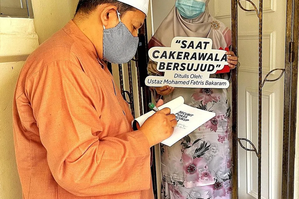 TANDA TANGAN PENULIS: Setiap buku buat Pakej Eksklusif ini ditanda tangani Ustaz Mohd Fatris (kiri) dan beliau sendiri akan mengikuti pegawai masjid untuk dihantar ke rumah penderma. - Foto MASJID DARUL MAKMUR