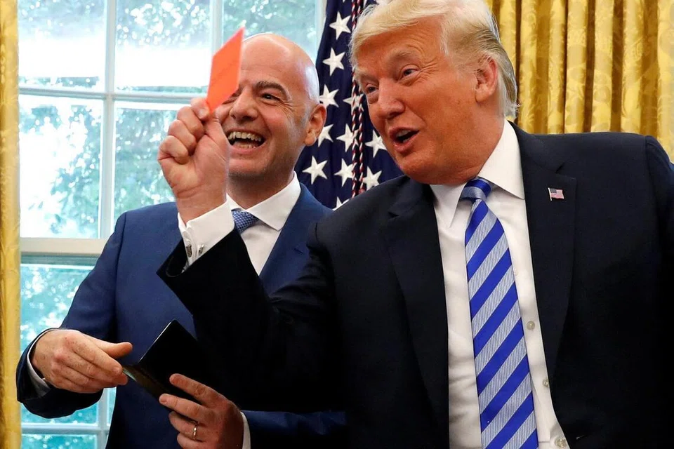 Foto Fail: Presiden Amerika Syarikat, Donald Trump, memegang kad merah sambil bergambar bersama Presiden Fifa, Gianni Infantino, di Pejabat Oval, Rumah Putih di Washington pada 28 Ogos 2018. Hubungan rapat antara kedua-dua tokoh itu kembali menjadi perhatian selepas FIFA menarik balik penggantungan penyerang AS, Folarin Balogun, susulan laporan bahawa Trump campur tangan secara langsung dengan menghubungi Infantino bagi membolehkan pemain itu beraksi menentang Belgium dalam Piala Dunia.