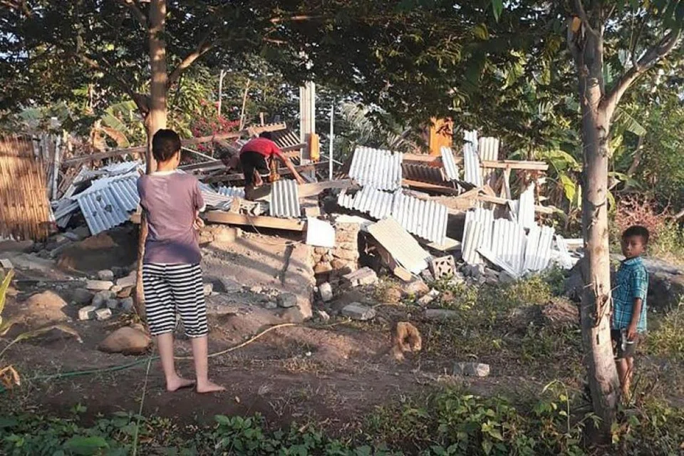 GEMPA BUMI: Penduduk melihat sebuah rumah yang runtuh akibat gempa bumi di Lombok pada 29 Julai 2018.
