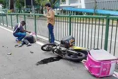 NAHAS JALAN RAYA: Seorang lelaki terbaring di jalan raya dekat motosikal yang turut terjatuh menyusuli satu nahas jalan raya di Balestier baru-baru ini.