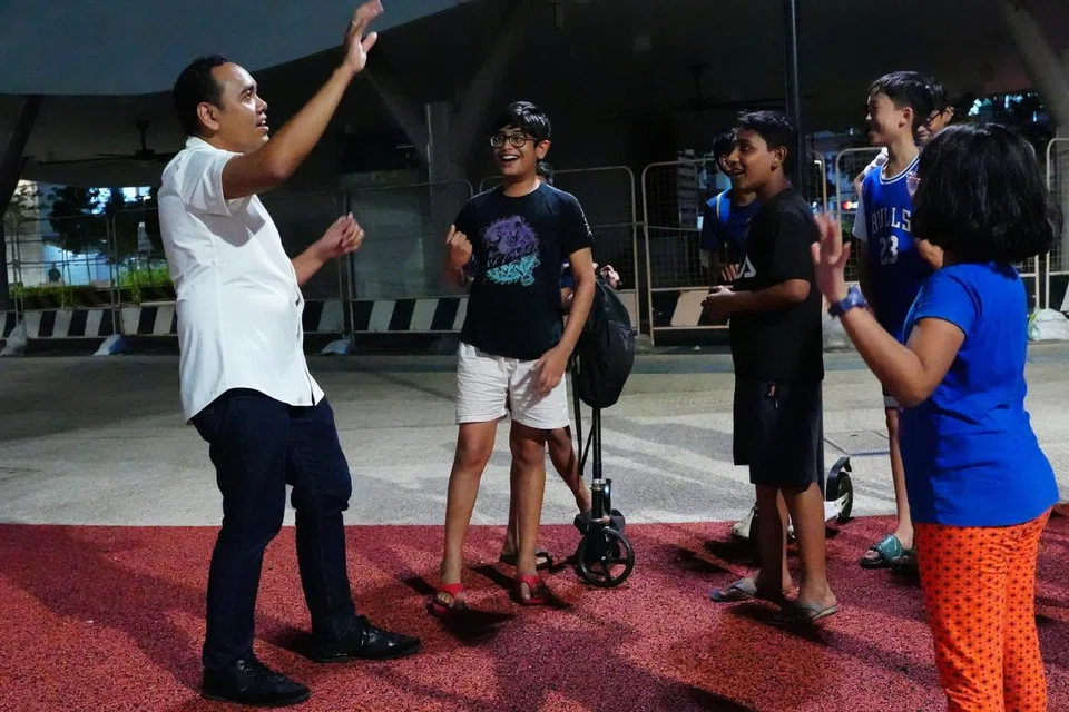 Anggota Parlimen (AP) GRC Chua Chu Kang, Encik Zhulkarnain Abdul Rahim (kiri) beramah mesra dengan para remaja di Keat Hong.