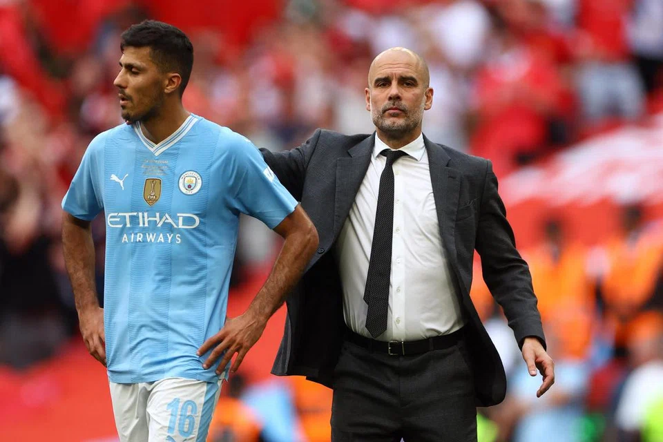 Pengurus Manchester City, Pep Guardiola (kanan), dan pemain midfield, Rodri, selepas perlawanan menentang Manchester United di London pada 25 Mei.