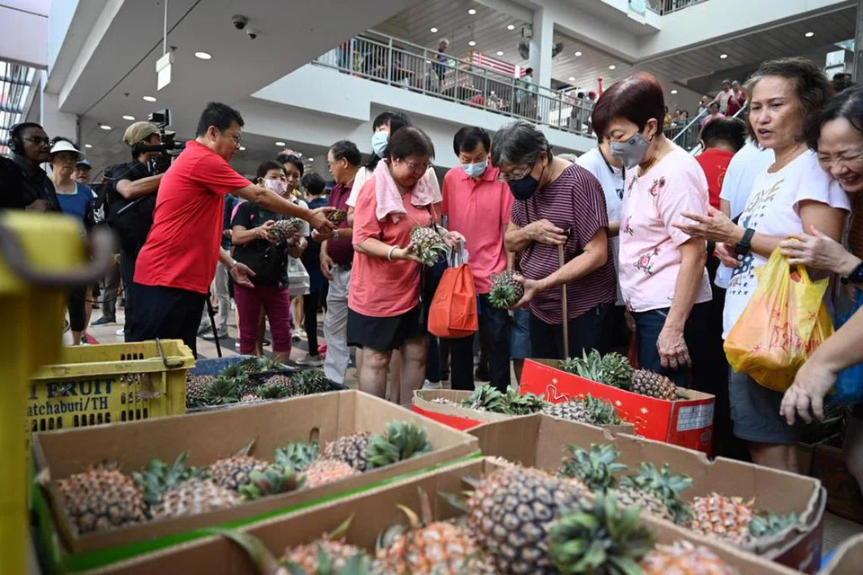 BERBAKUL NANAS: Orang ramai yang berkunjung ke Pusat Penjaja Taman Jurong mendapat nanas percuma.