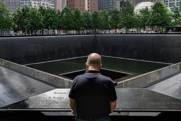 TEMPAT PERINGATAN: Seorang mangsa serangan 9/11 yang selamat, seakan bertafakur di Kolam Peringatan di Muzium dan Memorial 11 September di New York City yang memaparkan nama-nama mangsa yang terkorban dalam kejadian itu. - Foto AFP 