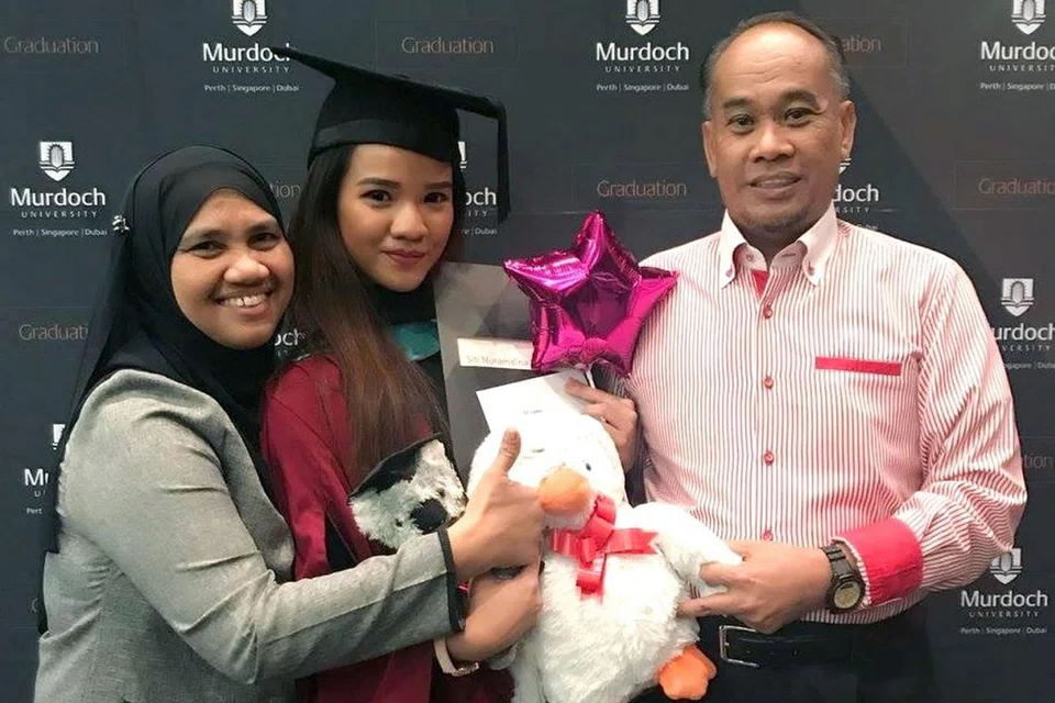 IKUT NASIHAT IBU BAPA: Cik Nuramalina (tengah) bersama ibunya, Cik Anita Haron, 52 tahun, dan bapanya, Encik Mohd Noor, 57 tahun, pada majlis konvokesyennya. Pesanan ibu bapanya menjadi dorongan kuat buat pelajar ini mendalami bidang pengajiannya tentang barah. - Foto ihsan SITI NURAMALINA MOHD NOOR