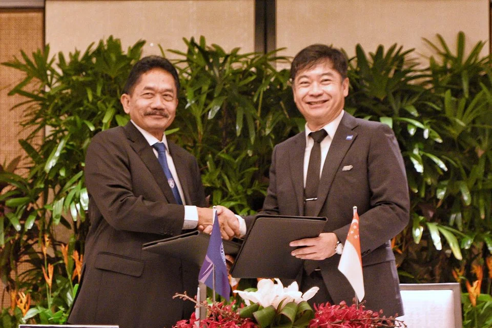 MANFAAT KERJASAMA: Pemangku presiden Persatuan Bola Sepak Singapura, Bernard Tan (kanan), bersalaman dengan presiden Persatuan Bola Sepak Johor, Ismail Karim, dalam majlis menandatangani Memorandum Persefahaman antara kededua persatuan di hotel Shangri-La Singapura pada Selasa.