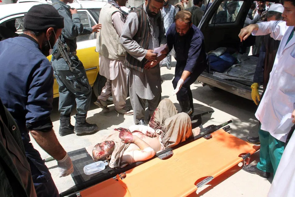 KEMALANGAN PALING BURUK: Penduduk tempatan membantu seorang lelaki yang cedera ke hospital selepas dua bas merempuh tangki minyak di lebuh raya di Ghazni, Afghanistan. - Foto REUTERS