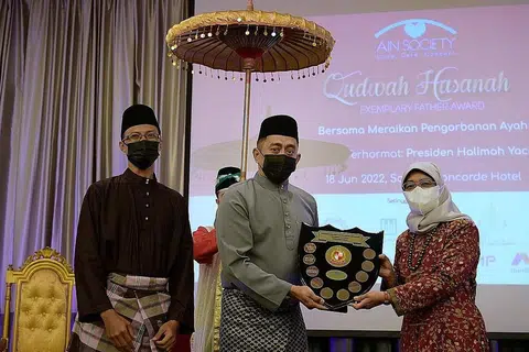 BAPA CONTOH: Presiden Halimah Yacob (kanan) menyampaikan Anugerah Qudwah Hasanah (Ayah Contoh Terbaik) 2022 kepada Encik Muhammad Mahadi Mohamed Ashim. Bersama mereka ialah presiden Persatuan Ain, Encik Md Fadzrun Adnan. - Foto BM oleh NG SOR LUAN