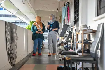 Cik Maisya Abdul Karim (kiri) dan Sharifah Muslimah Lili Ahmad Nassir (kanan), dua Duta Dian, memperkukuh keluarga di flat sewa di Blok 38 Bedok South Road menerusi Projek Dian.