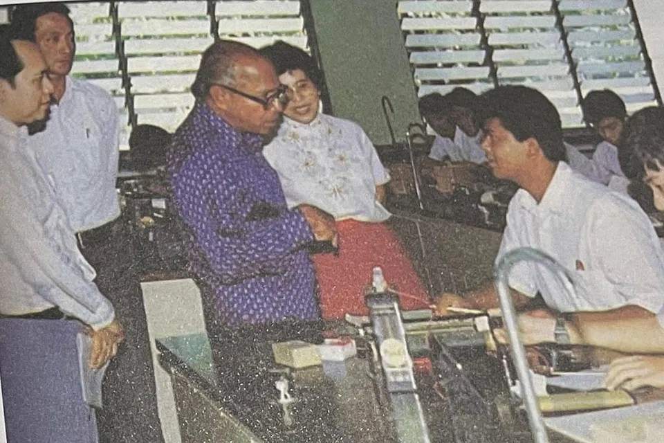 LAWATAN VIP: Gambar tetamu VIP ketika melawati Sekolah Sang Nila Utama, antaranya termasuklah Raja Permaisuri Agong Tengku Budriah, ditemani Wanita Pertama Singapura, Puan Noor Aishah. (Gambar atas) Turut dimuatkan di dalam buku ialah kunjungan mantan Presiden Devan Nair ke SNU pada 1982. - Foto HELANG BOOKS